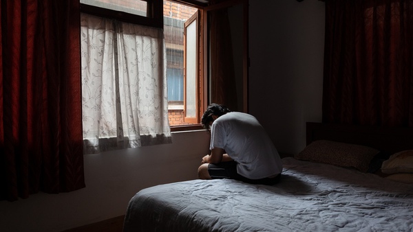 man sitting on bed