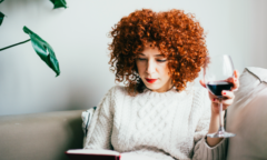 woman reading book drinking wine