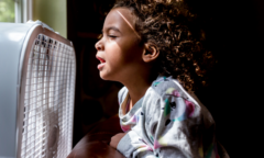 child in front of fan