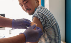 man getting a bandaid after receiving vaccine shot