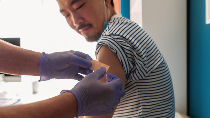 man getting a bandaid after receiving vaccine shot