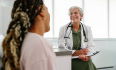 Older female physician speaks to patient